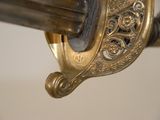 a close up of a sword with a gold handle