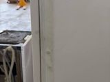a white refrigerator sitting in a kitchen next to a stove