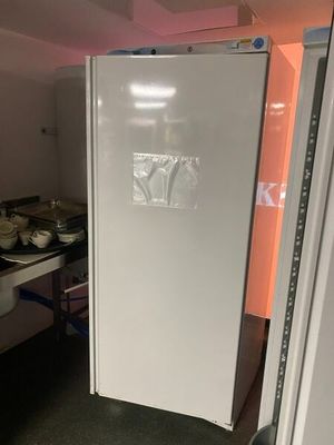 a white refrigerator in a small kitchen with a stove