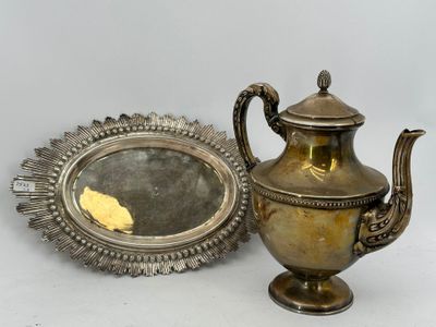 une théière en argent posée sur une table, à côté d'un miroir