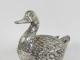 an antique silver duck figurine on a white background