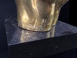 a gold statue of a man ' s head on top of a table