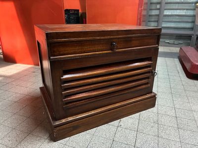 une commode en bois posée sur un sol carrelé