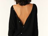 the back of a woman wearing a black top and jeans