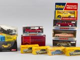 plusieurs petites voitures dans leurs boîtes et des cartons posés sur une surface blanche