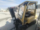 a yellow fork truck that is parked on the side of the road