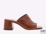 a close up of a pair of brown mules on a white background