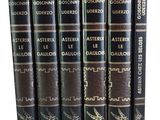 six livres empilés les uns sur les autres sur une surface blanche