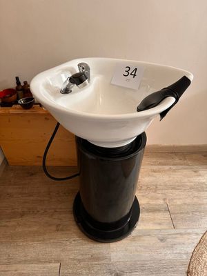 a black and white sink with a black handle on it