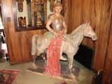 a statue of a woman riding a horse in a living room