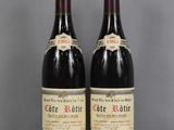 two bottles of wine sitting on top of a table next to each other