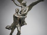 a bronze statue of a man and a woman on a rock