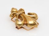 an image of a close up of a gold broochle on a white surface