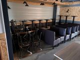 Des tables et des chaises sont alignées dans une pièce aux murs lambrissés.
