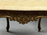 une table avec un plateau en marbre orné de motifs dorés