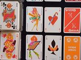 de nombreuses cartes à jouer posées sur une table, aux motifs très variés