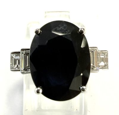 une image représentant une bague ornée d'une grosse pierre noire entourée de diamants