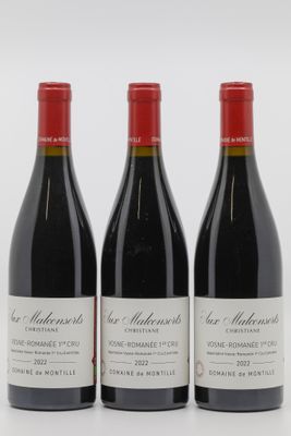 trois bouteilles de vin rouge sont posées côte à côte sur une surface blanche