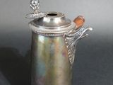 an antique silver plated coffee pot with a butterfly on the handle
