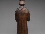 an old wooden statue of a man with a hat on his head