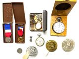 une boîte contenant une montre, une médaille, une autre médaille et d'autres objets