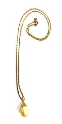a close up of a necklace on a white surface with a chain