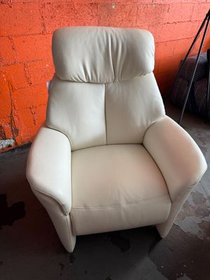un fauteuil inclinable blanc dans une pièce aux murs en briques