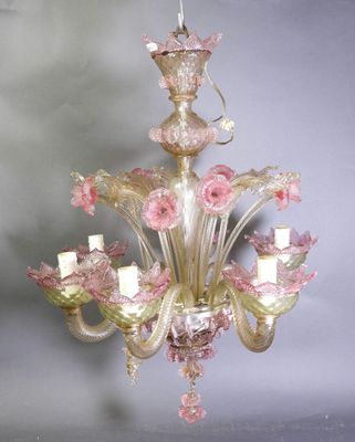 un lustre en verre duquel pendent des fleurs roses, suspendu au plafond