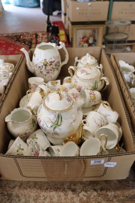 many cups and teapots in a box on the floor