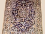 a blue and beige rug with a medallion design on it