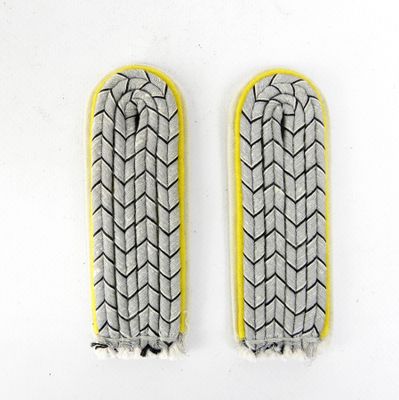 paire de mitaines tricotées à la main, grises et jaunes, ornées de chevrons noirs et blancs