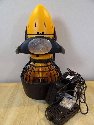 a yellow and black object sitting on a table next to a charger