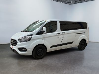 La camionnette blanche est garée dans une grande pièce aux murs blancs.