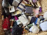 a wicker basket filled with various types of thread