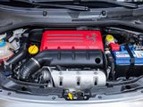 the engine of a car with a red battery in the trunk