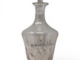crystal decanter with stopper on pedestal on white background