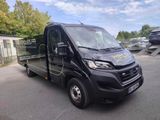 une photo d'une camionnette noire garée sur un parking