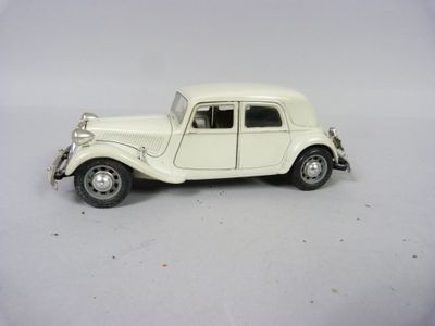 une petite voiture blanche posée sur une surface blanche