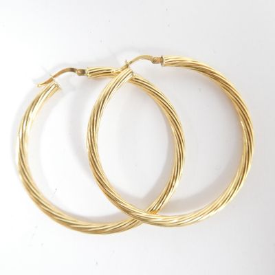 deux paires de boucles d'oreilles créoles en or sur fond blanc