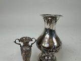 two silver vases sitting next to each other on a table