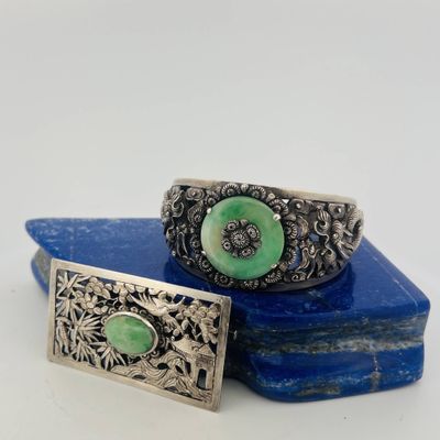 a pair of silver and green stone cuff bracelets