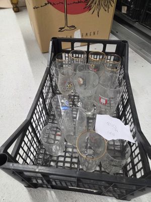 a basket full of empty wine glasses on the floor