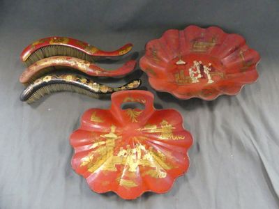 deux assiettes rouges ornées de motifs dorés, posées sur un fond gris
