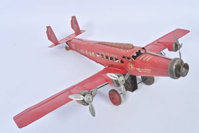 un petit avion rouge posé sur une surface blanche