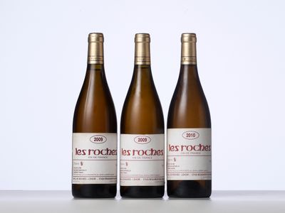 trois bouteilles de vin posées sur une table l'une à côté de l'autre