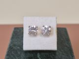 a pair of earrings sitting on top of a marble block