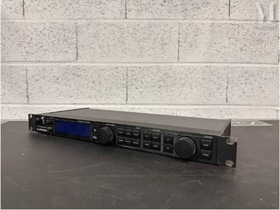 un gros plan d'une radio posée sur une table, avec un mur de briques en arrière-plan