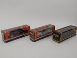 three boxed toy cars are sitting in a row on a white surface
