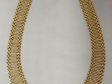 un collier en or sur fond blanc, avec une étiquette de prix