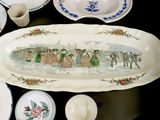 many plates and bowls on the table with a painting on them